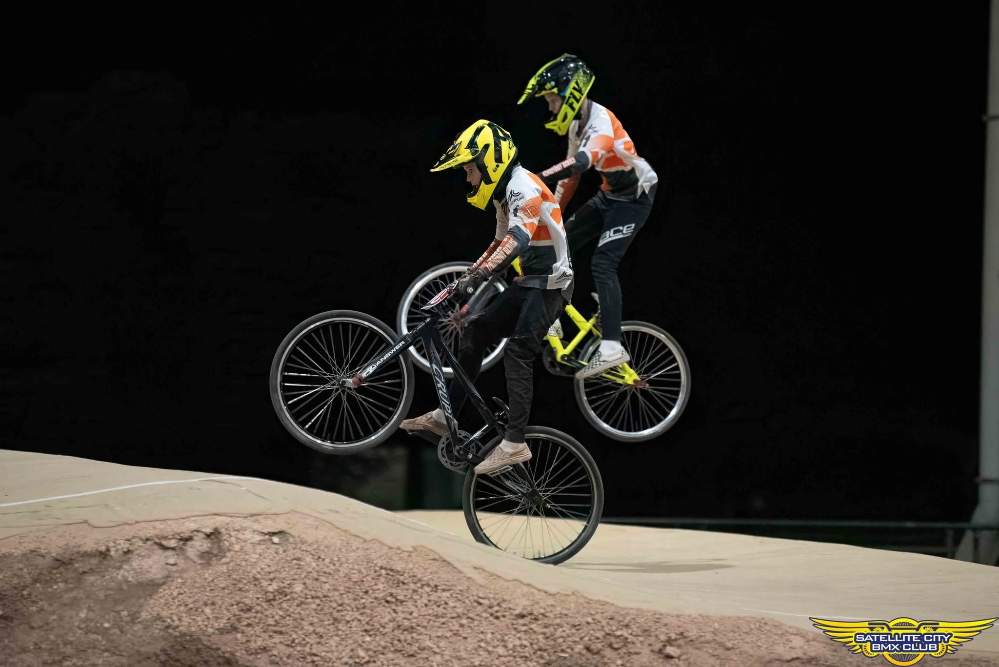 Young BMX rider in orange and pink competition gear